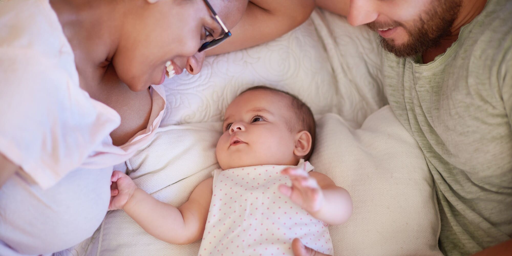 Shot of a happy young man and woman bonding with their adorable baby girl at home